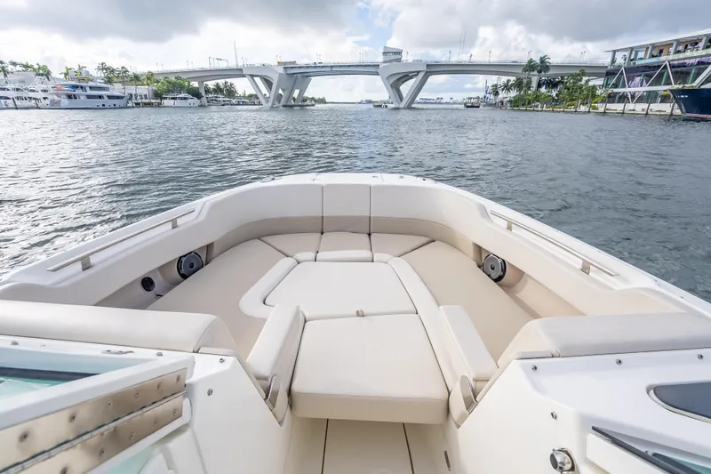 Trade In-- Bring All Offers & Trades Yacht Photos Pics 2024 Boston Whaler 320 Vantage boat interior with spacious seating, docked near a bridge.