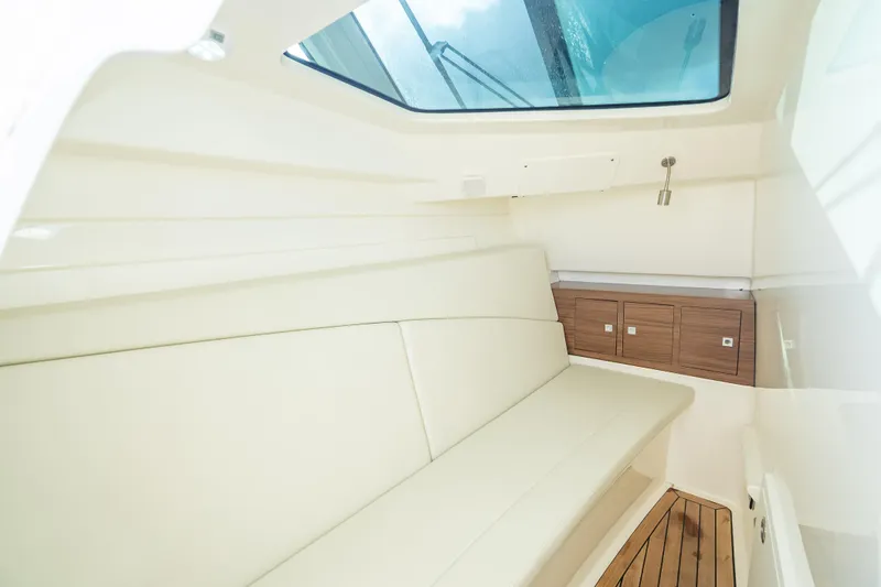 Trade In-- Bring All Offers & Trades Yacht Photos Pics 2024 Boston Whaler 320 Vantage cabin interior with skylight and wooden cabinetry.