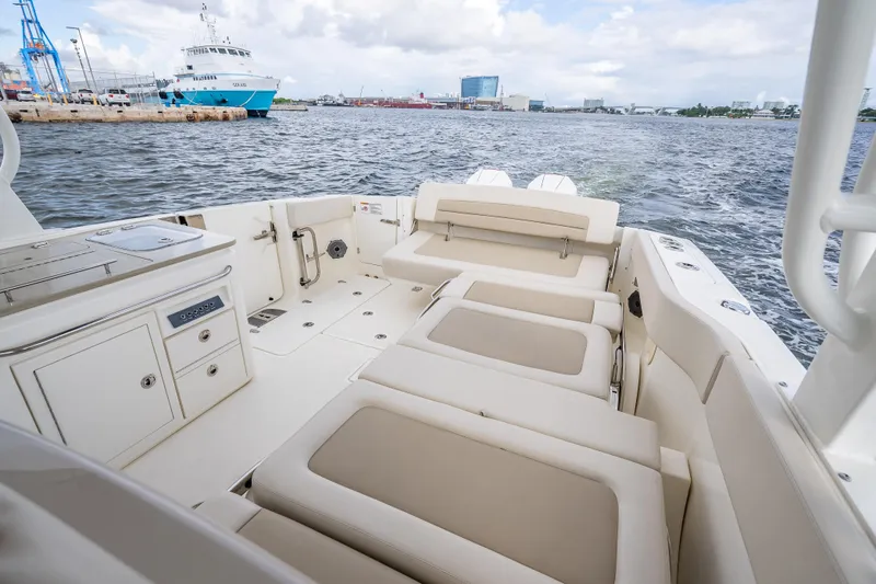 Trade In-- Bring All Offers & Trades Yacht Photos Pics 2024 Boston Whaler 320 Vantage boat interior with seating and storage, docked in a marina.
