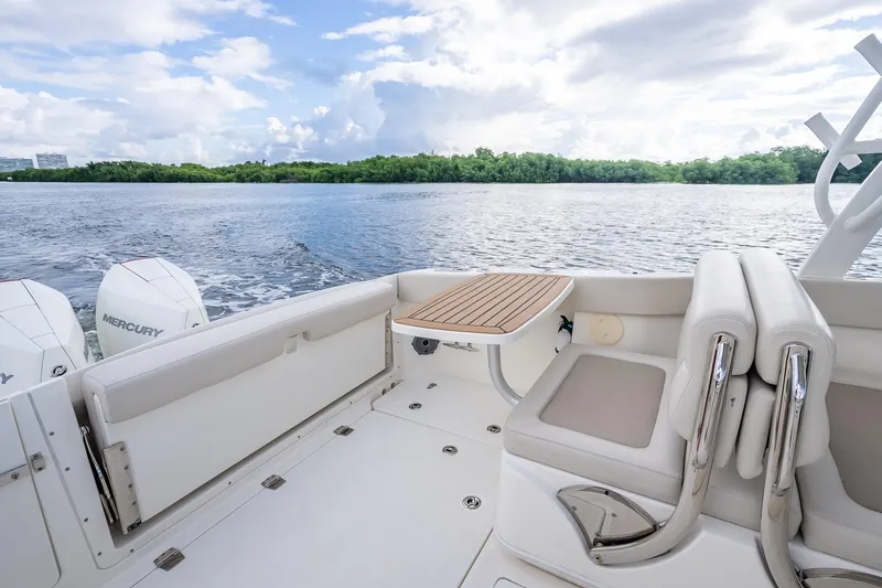 Trade In-- Bring All Offers & Trades Yacht Photos Pics 2024 Boston Whaler 320 Vantage boat interior with seating and table, overlooking serene water.