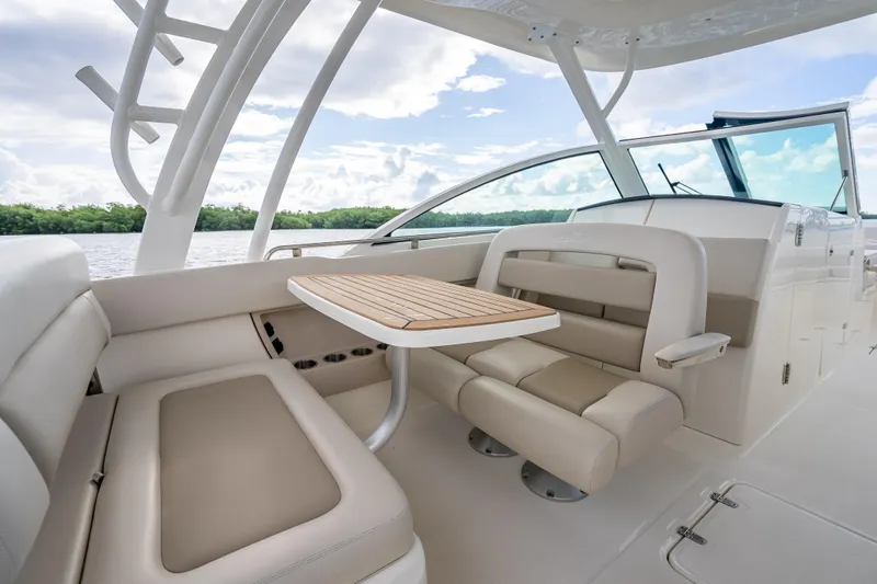 Trade In-- Bring All Offers & Trades Yacht Photos Pics 2024 Boston Whaler 320 Vantage interior with seating and table, overlooking water and sky.