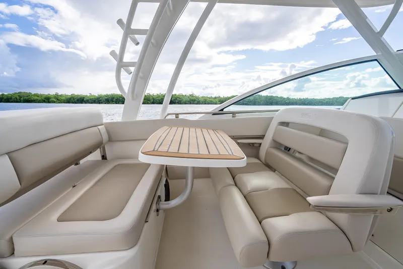 Trade In-- Bring All Offers & Trades Yacht Photos Pics 2024 Boston Whaler 320 Vantage interior with seating and table, overlooking scenic water view.