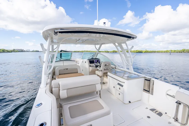 Trade In-- Bring All Offers & Trades Yacht Photos Pics 2024 Boston Whaler 320 Vantage boat interior, featuring seating and helm, on a sunny day.
