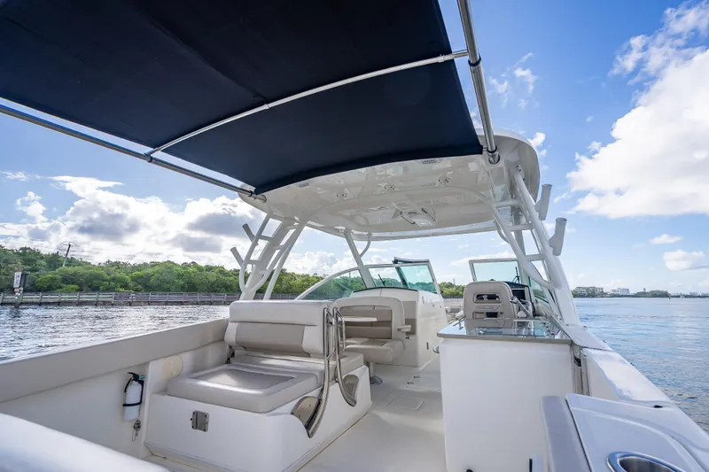 Trade In-- Bring All Offers & Trades Yacht Photos Pics 2024 Boston Whaler 320 Vantage boat interior with seating and canopy on a sunny day.