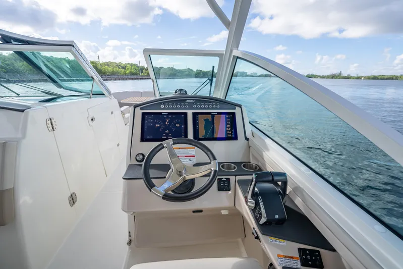 Trade In-- Bring All Offers & Trades Yacht Photos Pics 2024 Boston Whaler 320 Vantage helm with dual displays on a calm water backdrop.