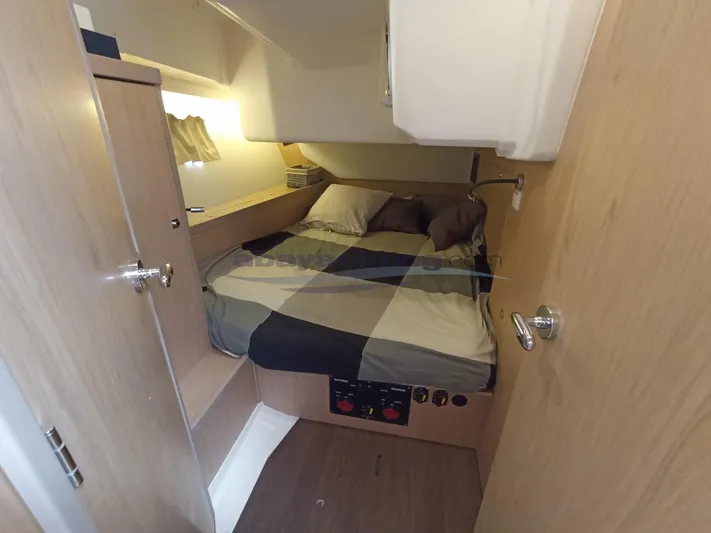  Yacht Photos Pics Cozy cabin interior of 2016 Beneteau Oceanis 45 sailboat with bed and wooden furnishings.