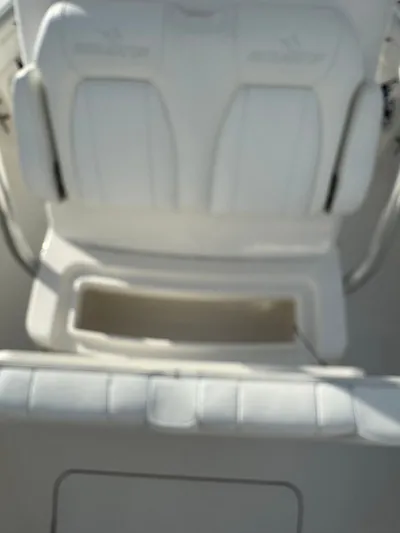 25 Regulator In Stock Yacht Photos Pics 2018 Regulator 25 boat seat with storage compartment, featuring white cushioned design.