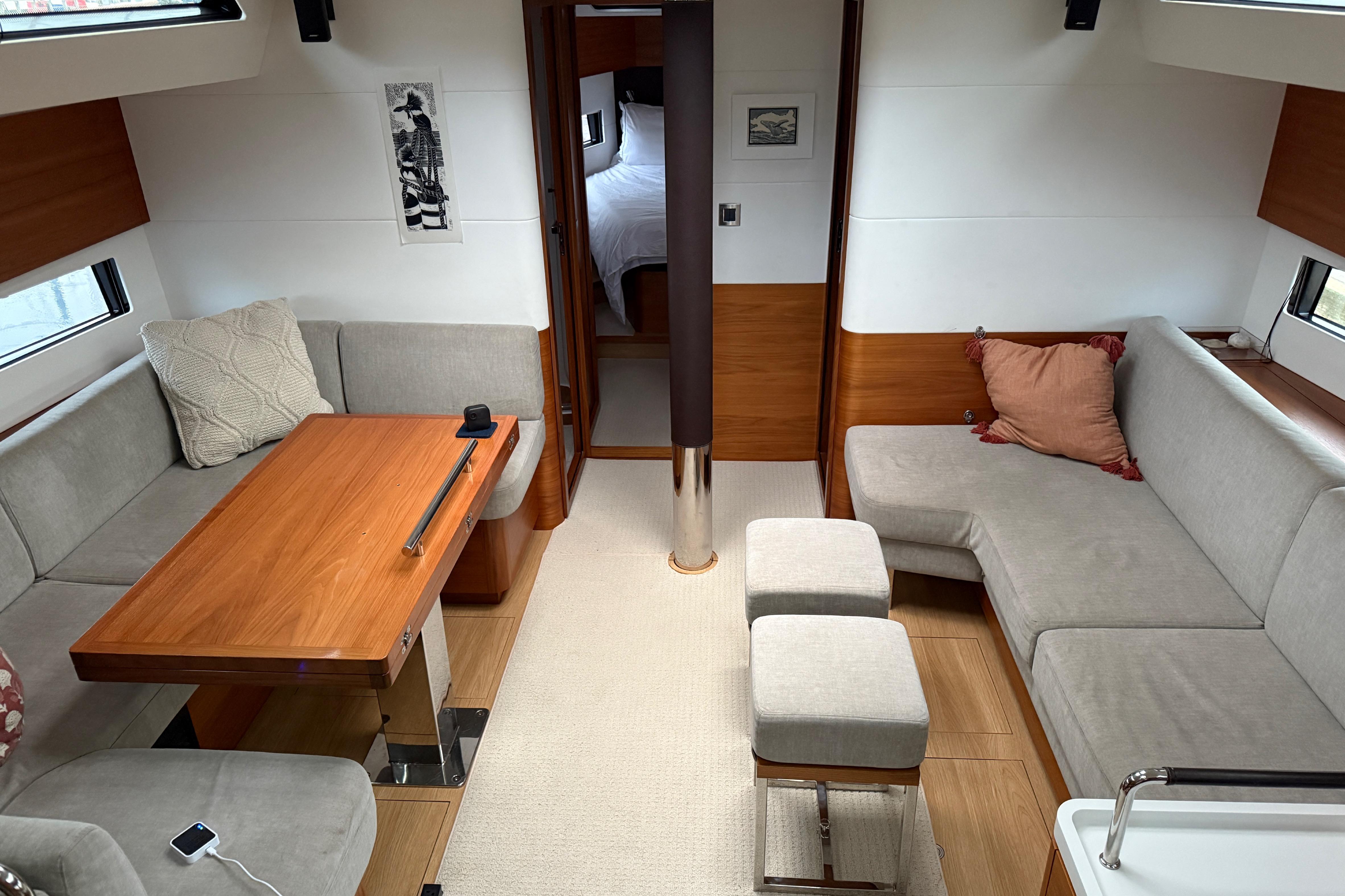 Luxurious interior of 2020 Amel 50 yacht with modern seating and wooden table.