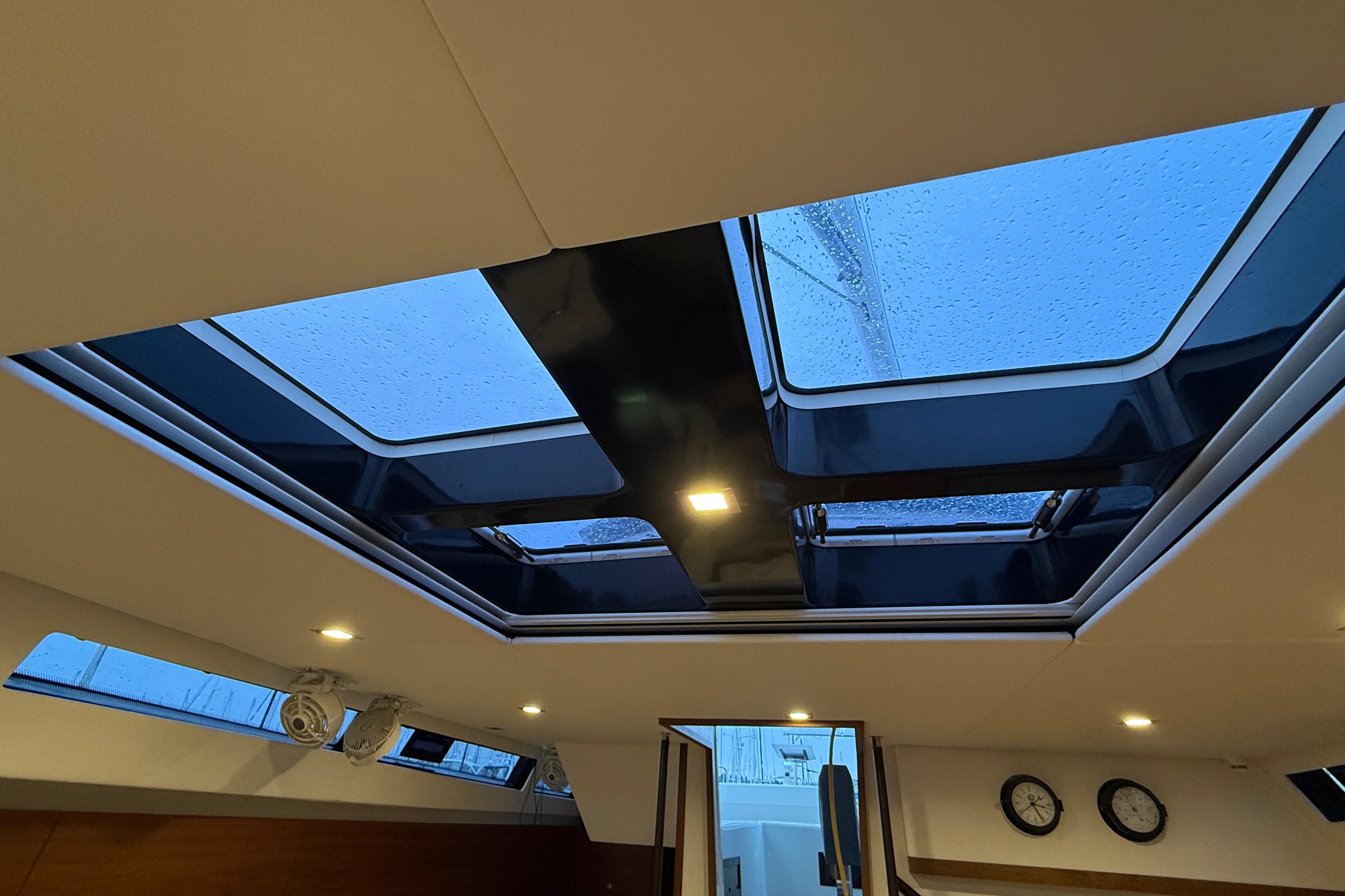 Interior view of 2020 Amel 50 yacht skylight with raindrops and modern lighting.