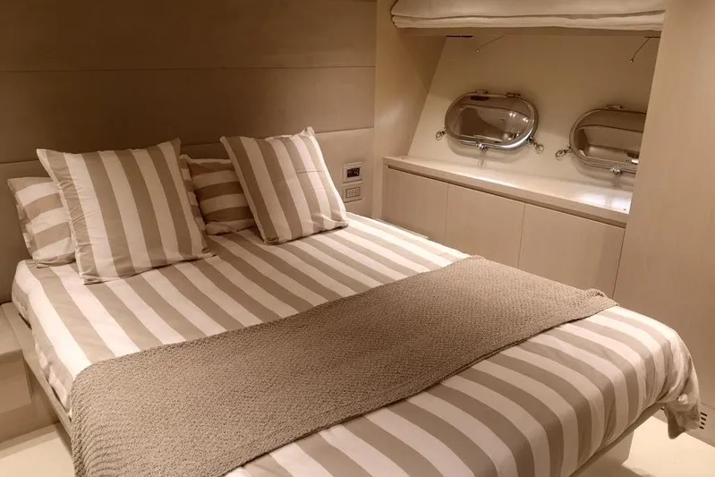  Yacht Photos Pics Luxurious bedroom interior of 2011 Sanlorenzo 72 yacht with striped bedding and porthole windows.