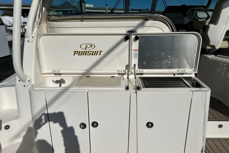  Yacht Photos Pics 2018 Pursuit OS 385 Offshore boat interior with sink and grill station.