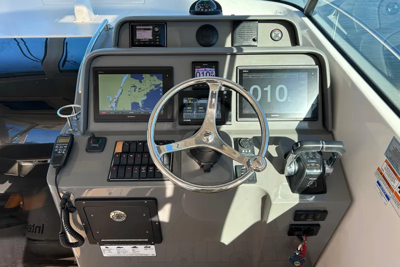  Yacht Photos Pics 2018 Pursuit OS 385 Offshore helm with navigation screens and steering wheel.