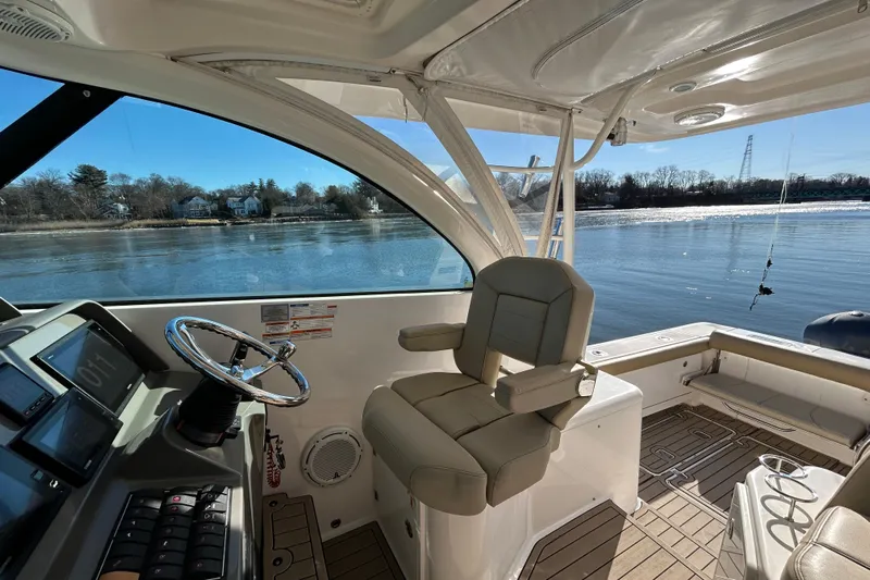  Yacht Photos Pics 2018 Pursuit OS 385 Offshore boat interior with helm and seating, overlooking calm waters.