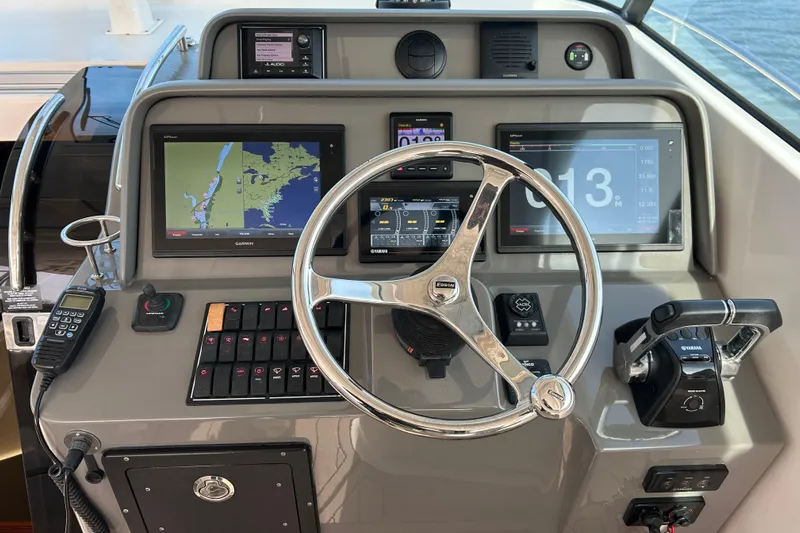  Yacht Photos Pics Control panel of 2018 Pursuit OS 385 Offshore boat with navigation screens and steering wheel.