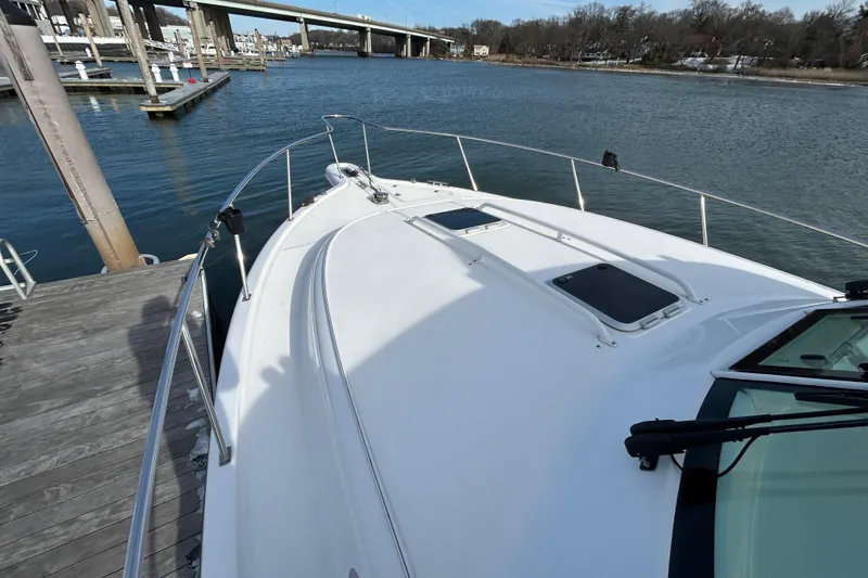  Yacht Photos Pics 2018 Pursuit OS 385 Offshore boat docked by a serene waterfront.