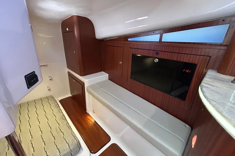  Yacht Photos Pics 2018 Pursuit OS 385 Offshore cabin interior with wood paneling and seating.