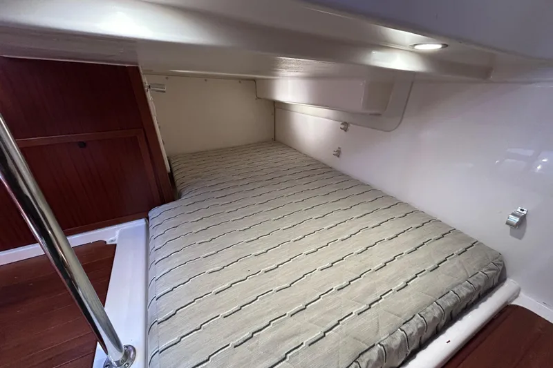  Yacht Photos Pics 2018 Pursuit OS 385 Offshore cabin interior with cozy bed and wooden accents.