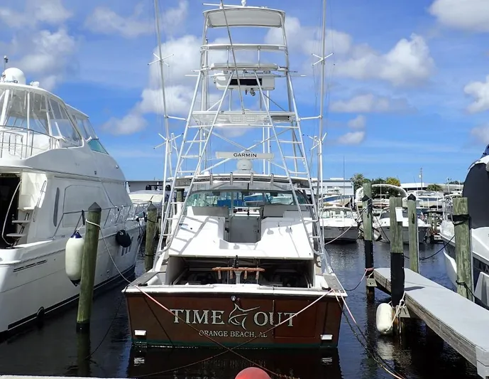 Time Out Yacht Photos Pics 2000 Cabo 35 Express boat docked at marina under blue sky.