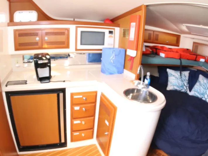 Time Out Yacht Photos Pics Interior of 2000 Cabo 35 Express yacht with kitchenette and cozy sleeping area.