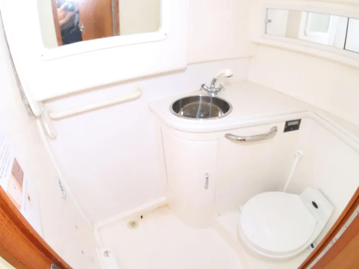 Time Out Yacht Photos Pics Compact bathroom in 2000 Cabo 35 Express boat with sink and toilet.