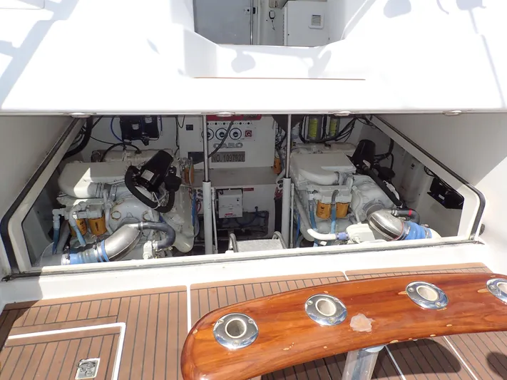 Time Out Yacht Photos Pics Engine compartment of 2000 Cabo 35 Express yacht, showcasing dual engines and teak deck.
