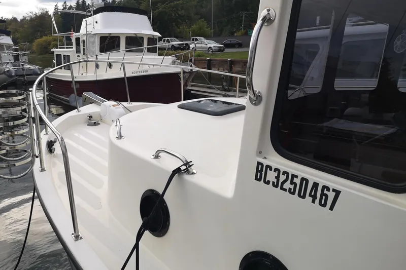  Yacht Photos Pics 1990 Nordic Tug 32 docked at marina, showcasing boat details and registration number.