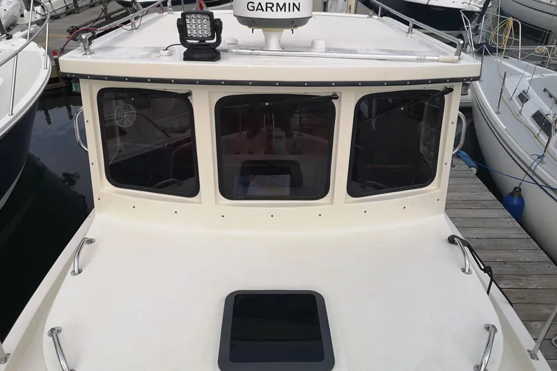  Yacht Photos Pics 1990 Nordic Tug 32 boat docked, featuring Garmin equipment and spacious deck.