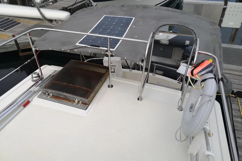  Yacht Photos Pics 1990 Nordic Tug 32 boat deck with solar panel, life preserver, and hatch.