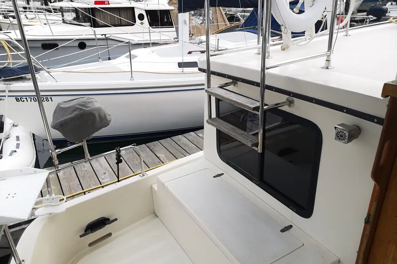  Yacht Photos Pics 1990 Nordic Tug 32 docked, featuring a ladder and deck area.