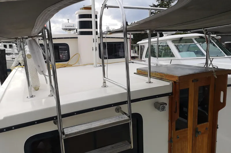  Yacht Photos Pics 1990 Nordic Tug 32 boat with wooden doors and metal railings at a marina.