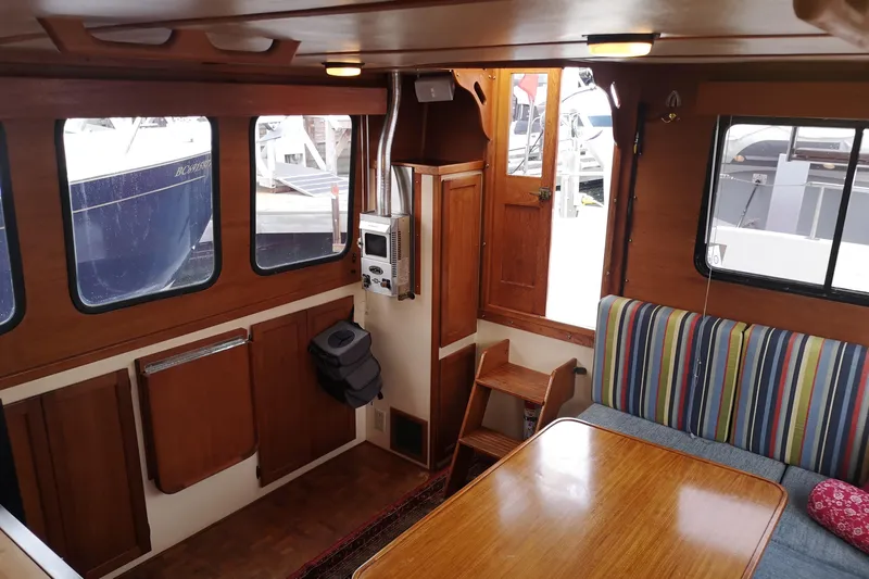  Yacht Photos Pics Interior of a 1990 Nordic Tug 32 with wood paneling and striped seating.
