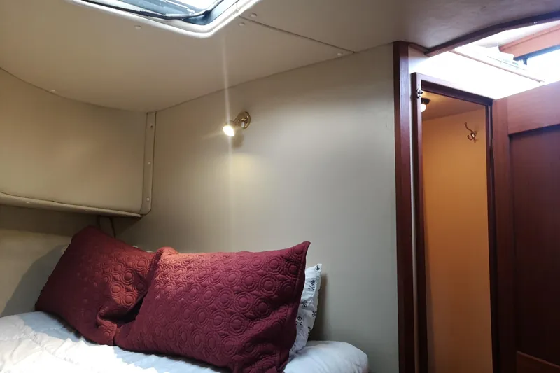  Yacht Photos Pics Cozy cabin interior of 1990 Nordic Tug 32 with red pillows and soft lighting.