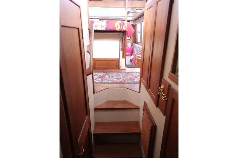  Yacht Photos Pics Interior of 1990 Nordic Tug 32 with wooden stairs and cozy cabin decor.