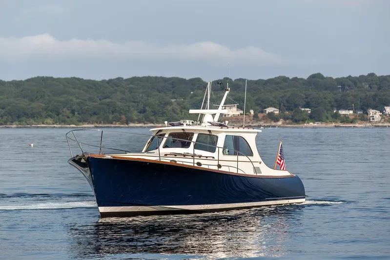 Summer Yacht Photos Pics 2002 Hinckley Talaria 44 yacht cruising on calm waters with scenic shoreline backdrop.
