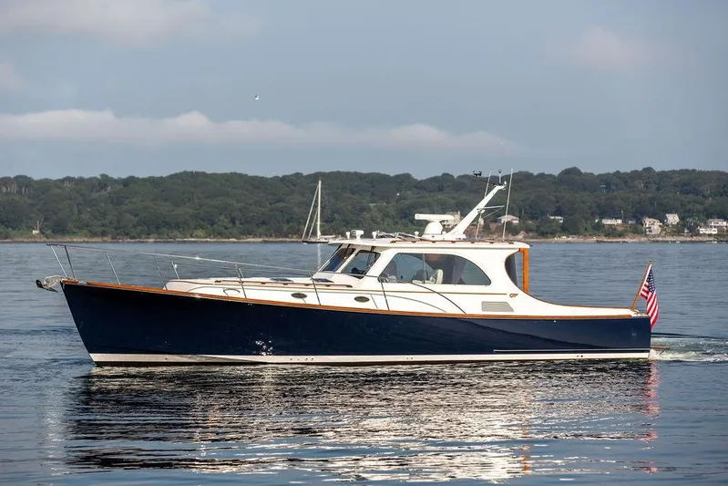 Summer Yacht Photos Pics 2002 Hinckley Talaria 44 yacht cruising on calm waters with scenic shoreline backdrop.