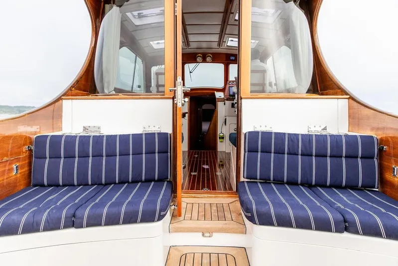 Summer Yacht Photos Pics Interior view of 2002 Hinckley Talaria 44 yacht with striped seating and wooden finishes.