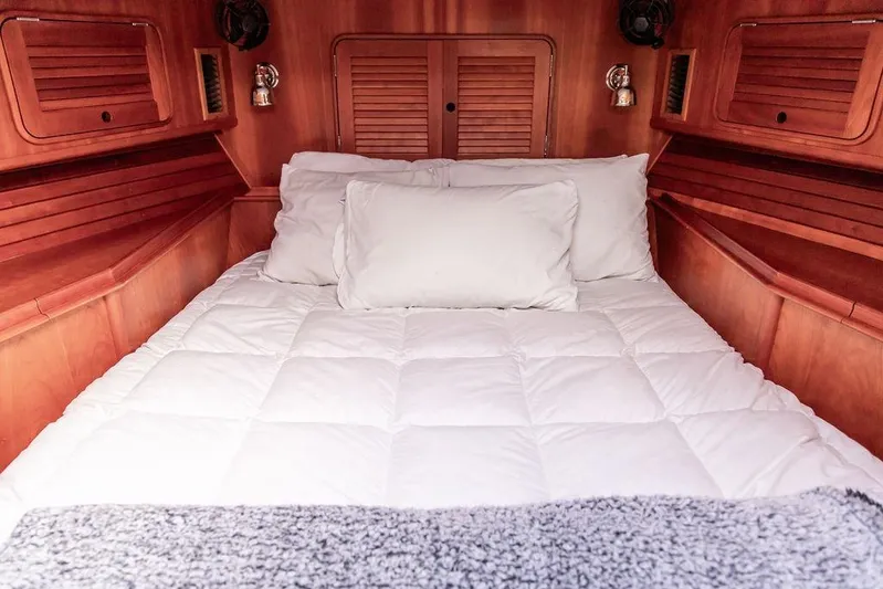 Summer Yacht Photos Pics Cozy cabin interior of 2002 Hinckley Talaria 44 with plush bedding and wooden accents.