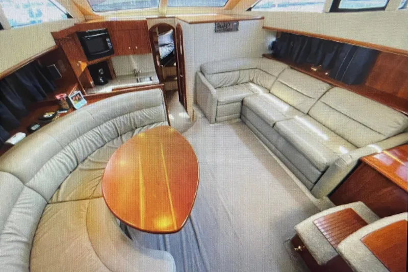 It's Flight O'clock Somewhere Yacht Photos Pics Luxurious interior of 2006 Cruisers Yachts 385 Motoryacht with plush seating and kitchenette.