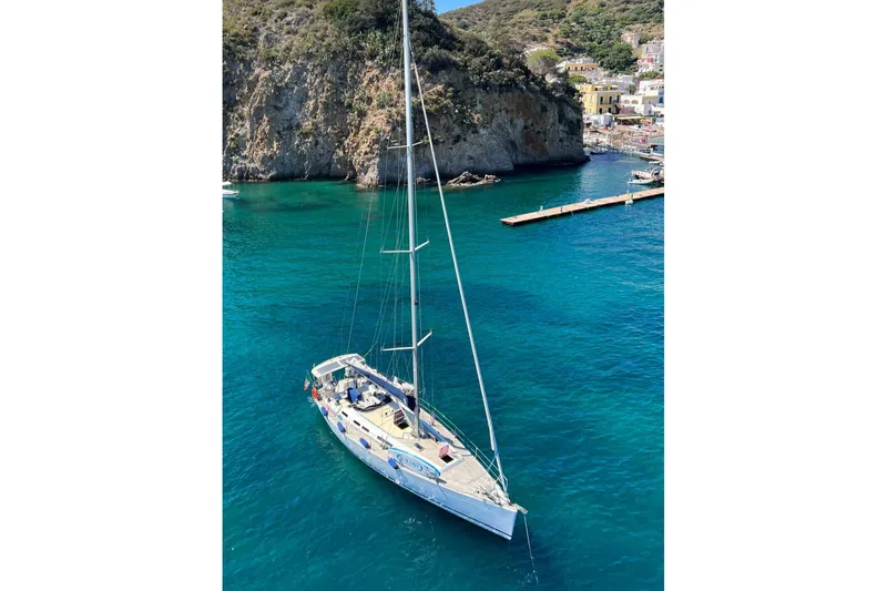 Yacht Photos Pics Sailing yacht Grand Soleil 50, 2009, anchored in clear blue waters near rocky coastline.