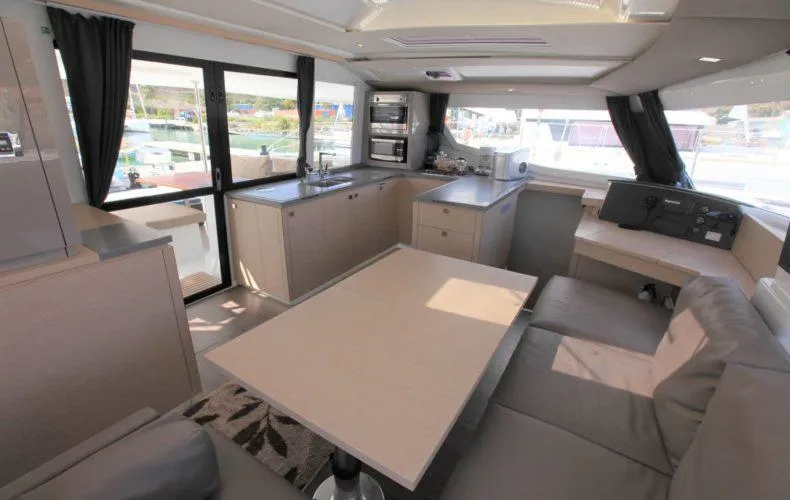 Anila Yacht Photos Pics Luxurious interior of 2018 Fountaine Pajot Helia 44 Evolution catamaran, featuring modern kitchen and seating area.