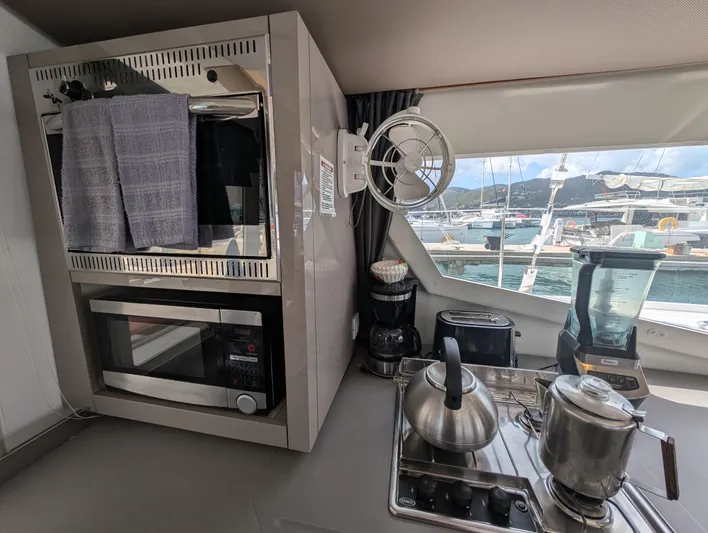 Anila Yacht Photos Pics Modern kitchen in 2018 Fountaine Pajot Helia 44 Evolution yacht with appliances and marina view.
