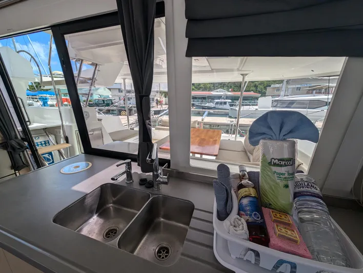 Anila Yacht Photos Pics Interior view of 2018 Fountaine Pajot Helia 44 Evolution catamaran kitchen with marina backdrop.