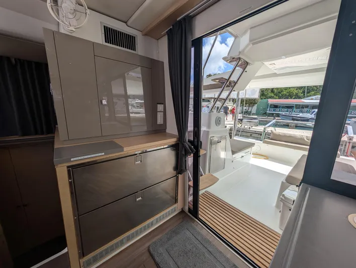 Anila Yacht Photos Pics Interior view of 2018 Fountaine Pajot Helia 44 Evolution catamaran, featuring modern cabinetry and outdoor seating.