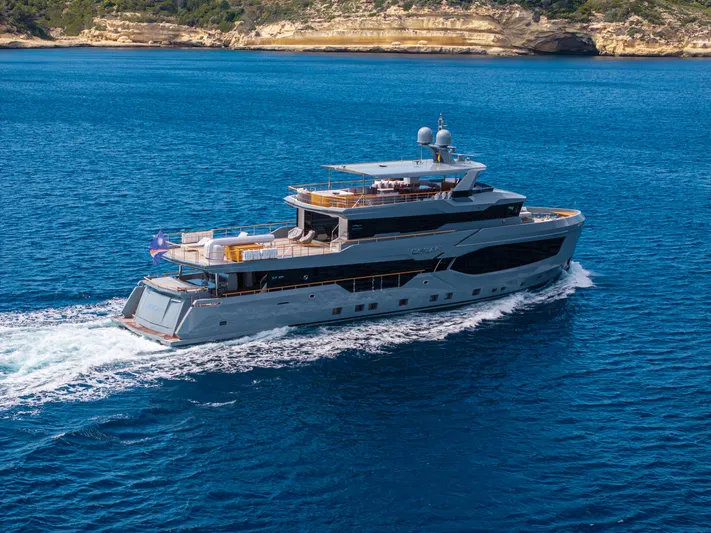 Oscar Yacht Photos Pics 2023 Numarine 37XP yacht cruising in clear blue waters near rocky coastline.