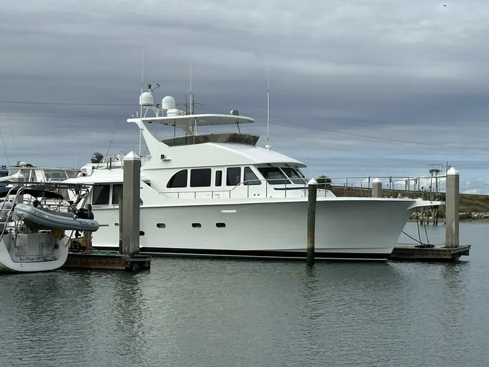  Yacht Photos Pics 2004 Cheoy Lee 72 yacht docked at marina under cloudy sky.
