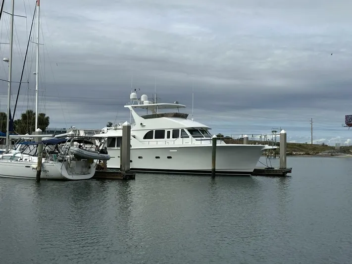  Yacht Photos Pics 2004 Cheoy Lee 72 yacht docked beside sailboats under cloudy skies.