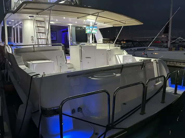  Yacht Photos Pics Luxurious 2004 Cheoy Lee 72 yacht docked at night with illuminated deck.