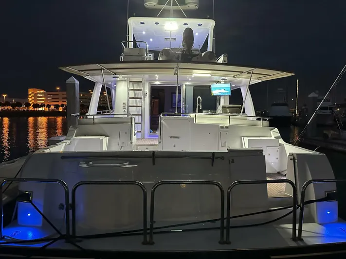  Yacht Photos Pics 2004 Cheoy Lee 72 yacht docked at night, illuminated with blue lights.