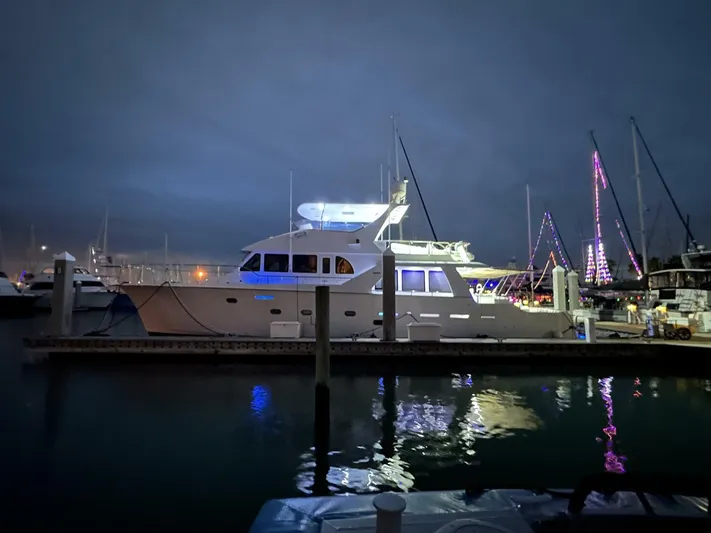 Yacht Photos Pics 2004 Cheoy Lee 72 yacht illuminated at night in a marina setting.