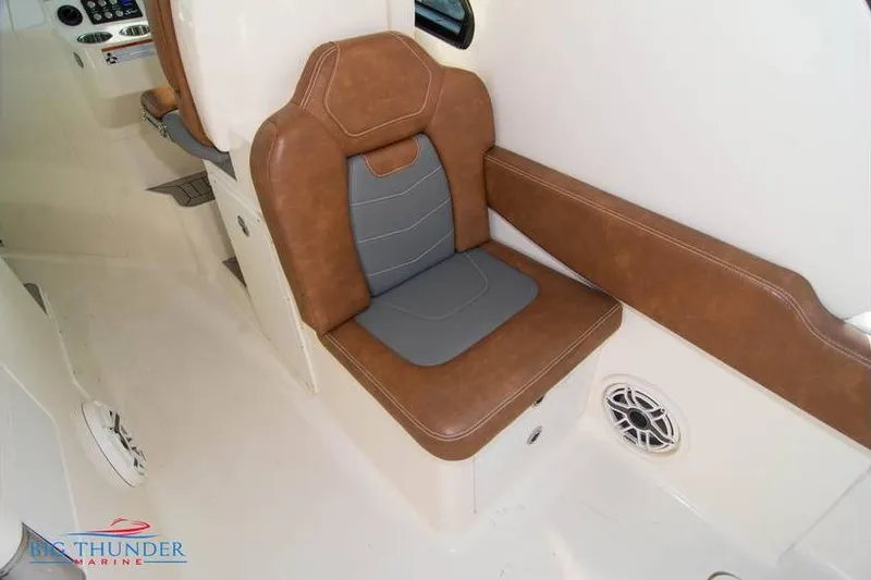  Yacht Photos Pics 2022 Scout 350 LXZ boat interior with brown and gray seating, speaker, and control panel.
